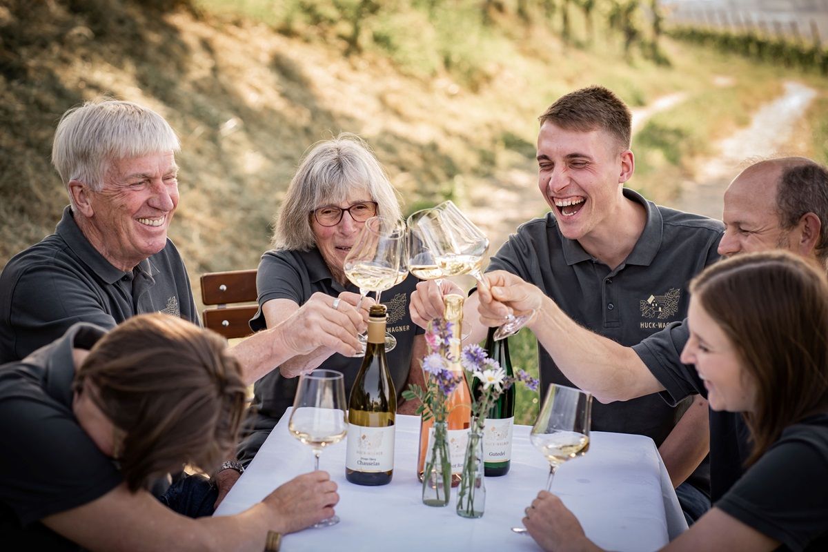Gruppe sitzt am Tisch und trinkt Wein