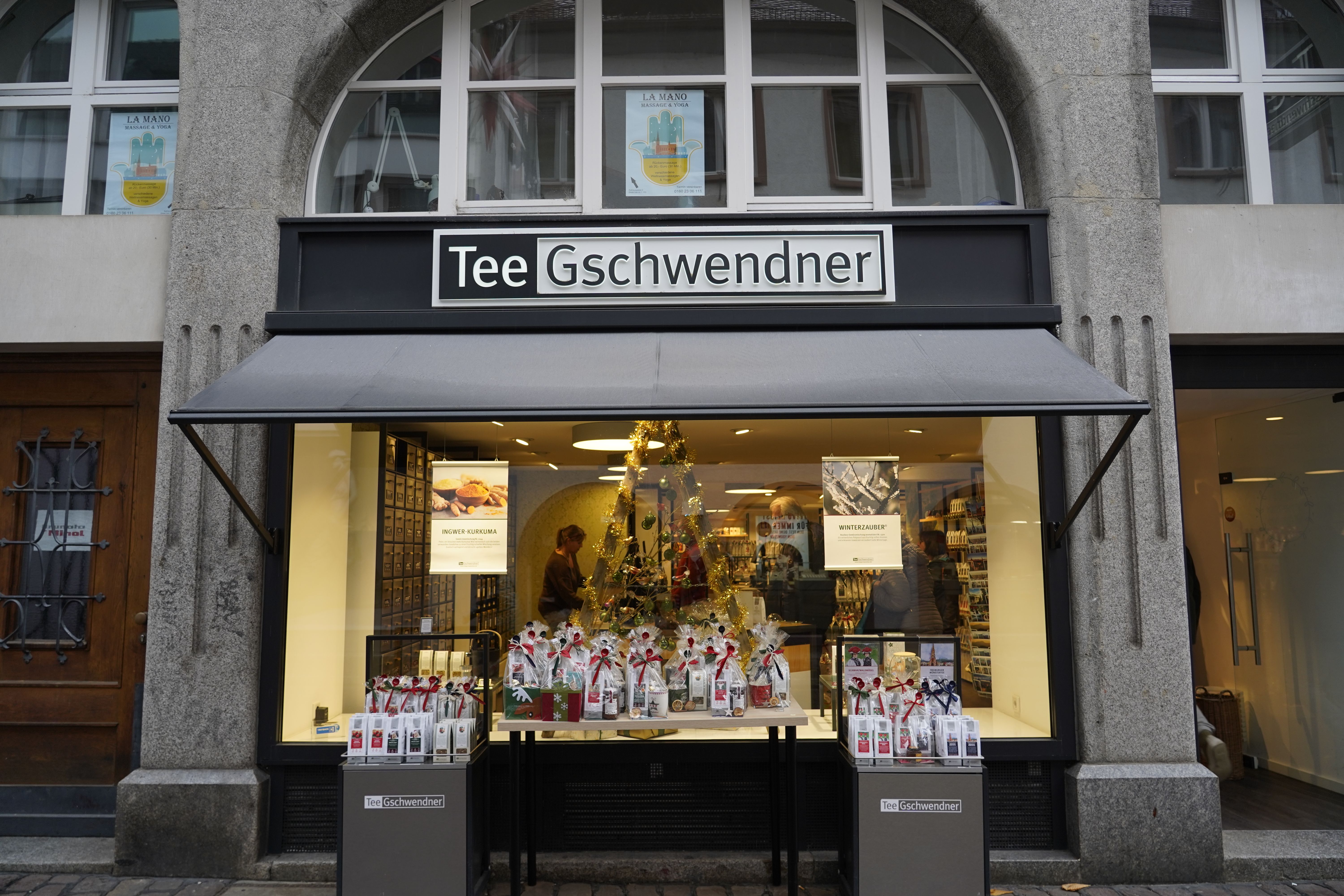 Tee Gschwendner Laden in Freiburg mit weihnachtlich dekoriertem Schaufenster und Teepaketen auf einem Tisch.