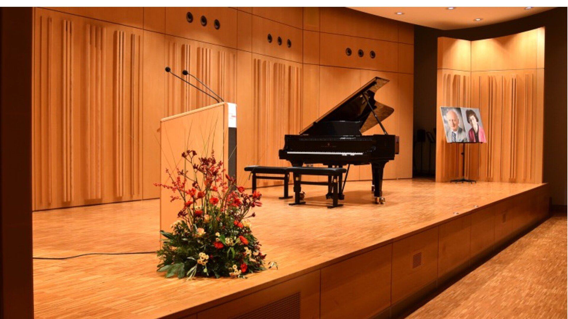 Kammermusiksaal mit Rednerpult, Flügel und den Fotos von Anna und Ernst Seidel