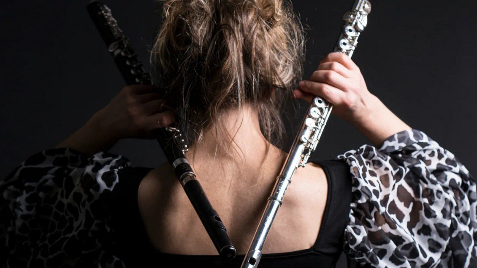 Zwei Querflöten bilden ein V auf dem Rücken von Wally Hase