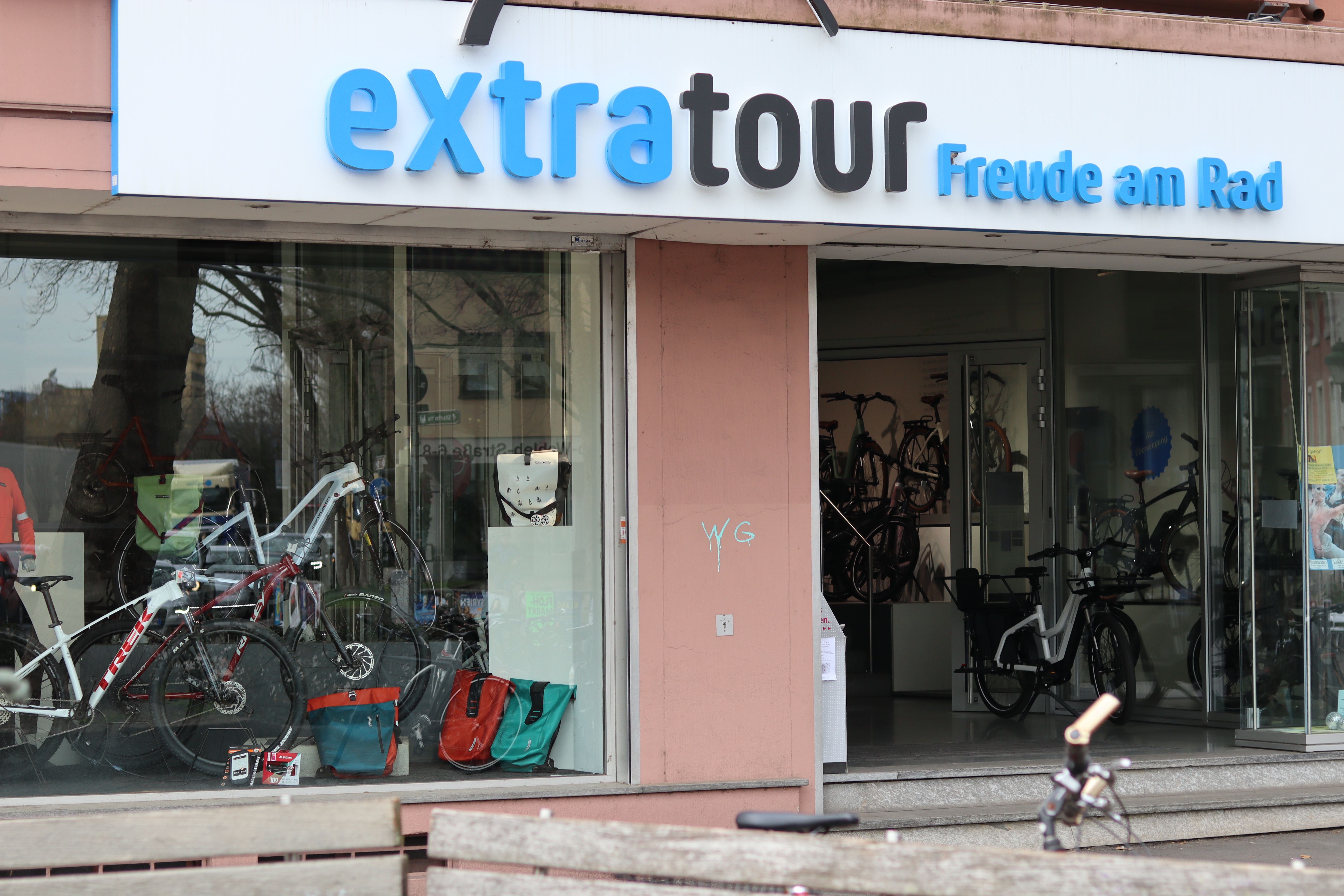 Fahrradgeschäft 'extratour' in Freiburg mit Schaufenster voller Fahrräder und Zubehör. Der Schriftzug 'Freude am Rad' ist sichtbar.