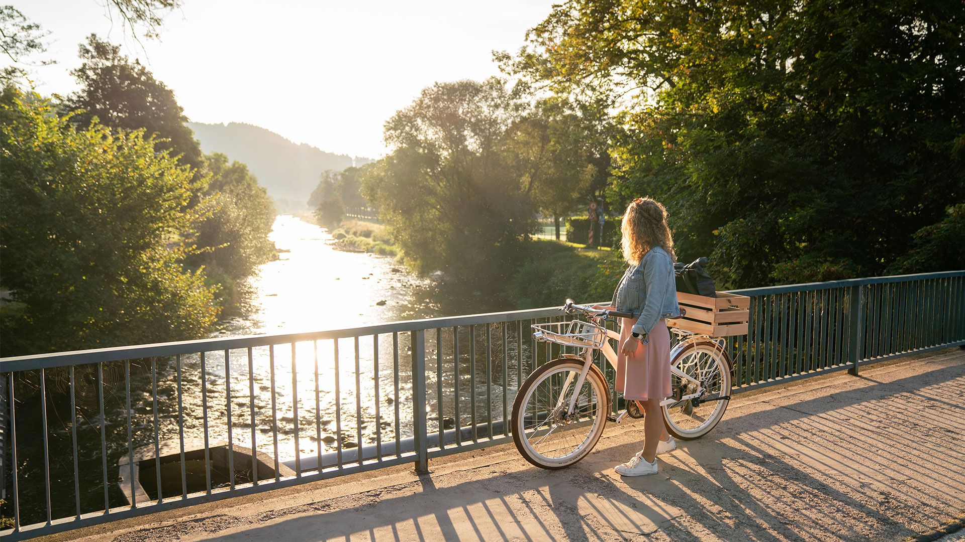 Frau mit Fahrrad auf einer Brücke an der Dreisam 