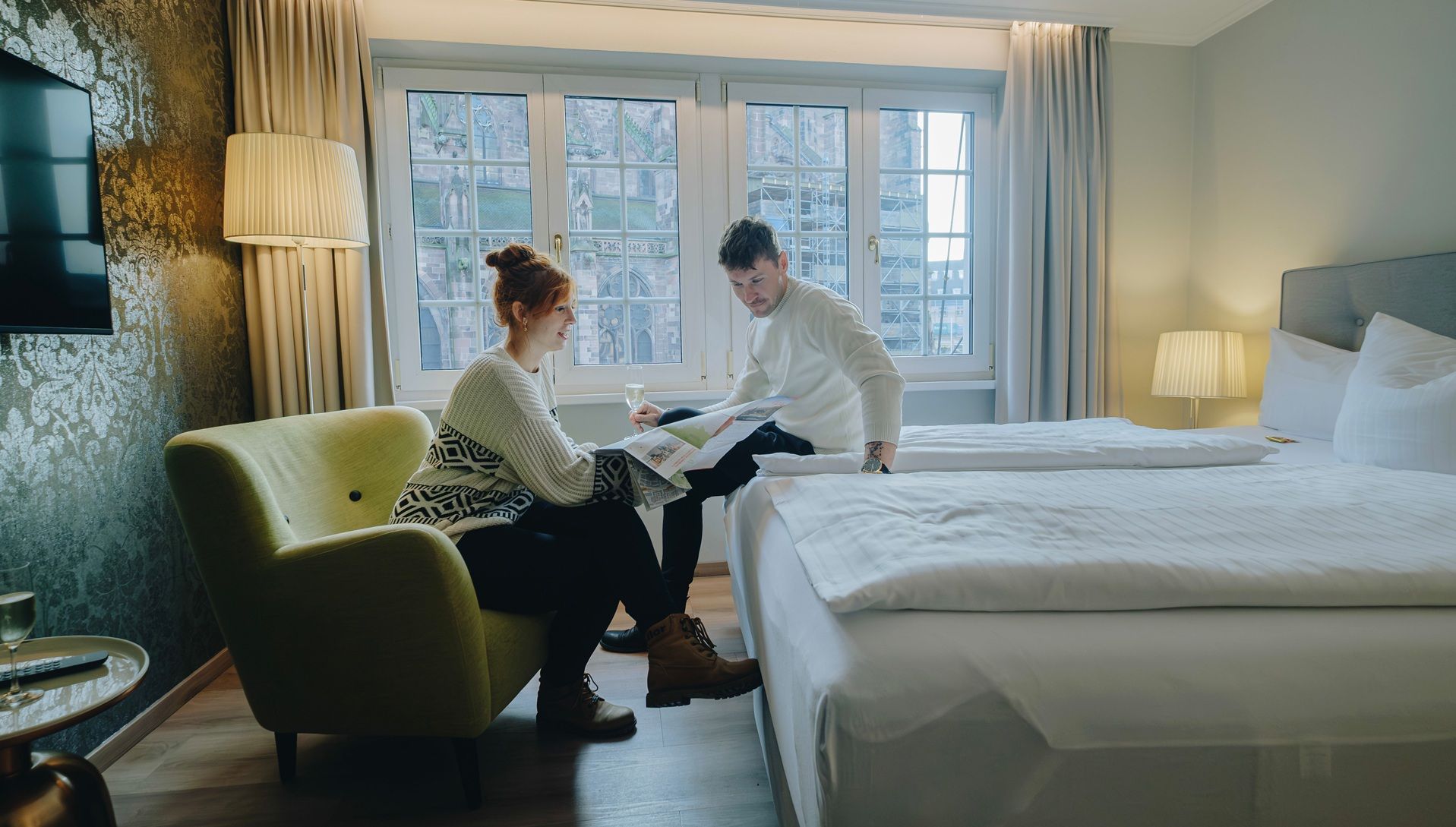 Paar liest Stadtplan von Freiburg in Hotelzimmer