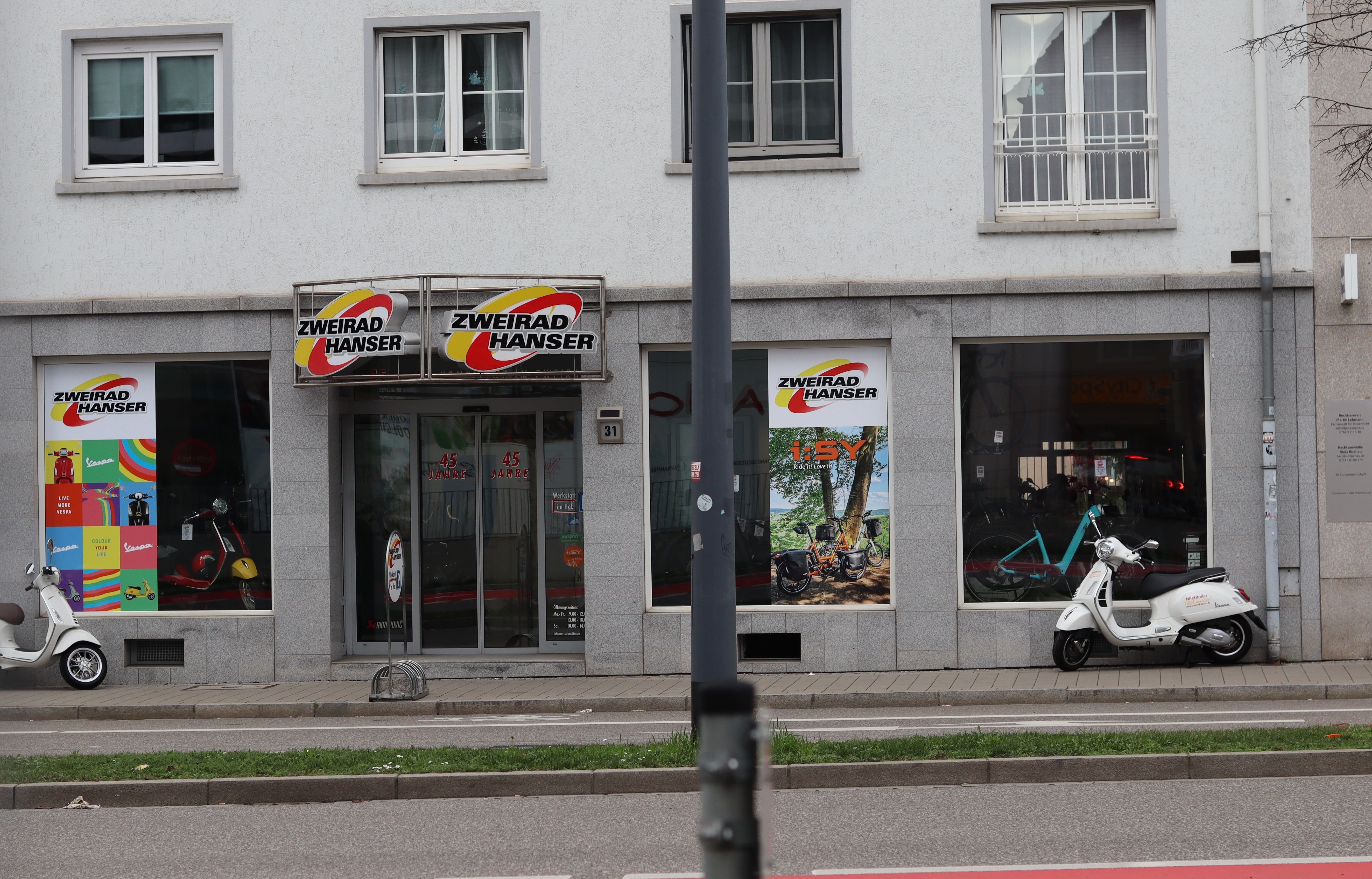 Fahrradgeschäft Zweirad Hanser in Freiburg mit Schaufenstern, Rollern und Fahrrädern. 