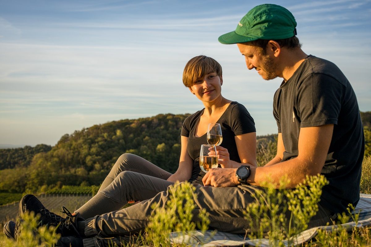 Zwei Personen picknicken vor der Kulisse des Kaiserstuhls