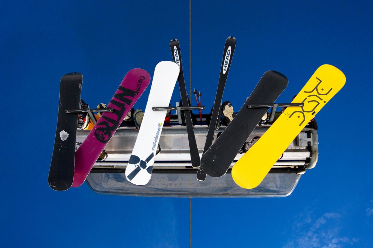 Ski und Snowboards von unten fotografiert auf einem Sessellift