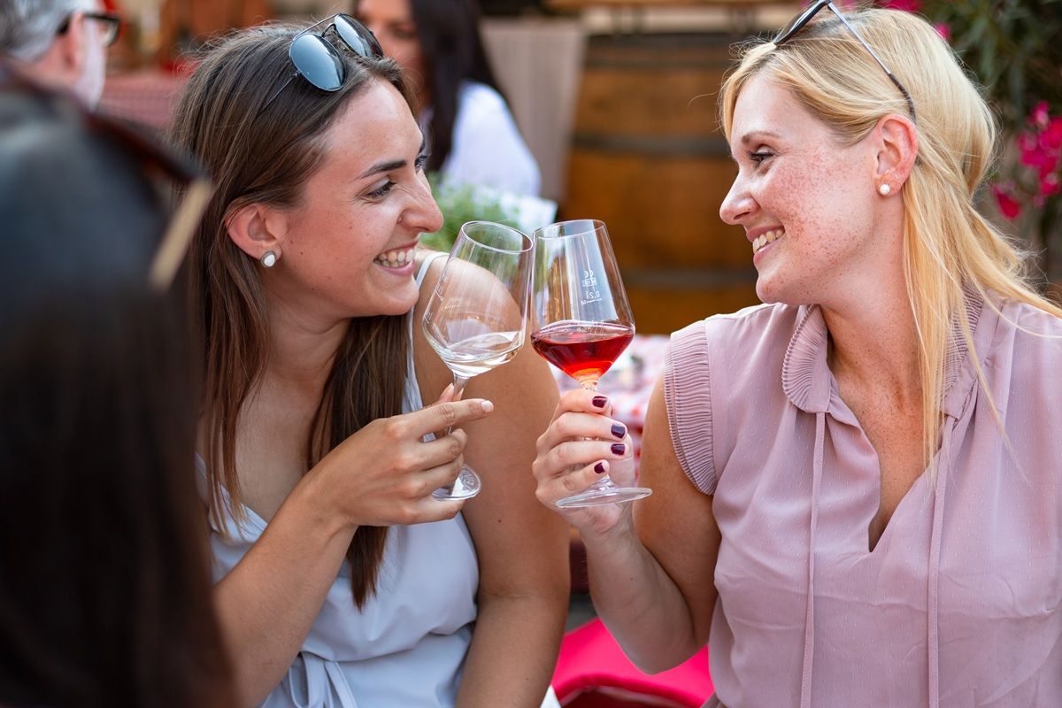 Zwei Frauen stoßen mit Weingläsern an