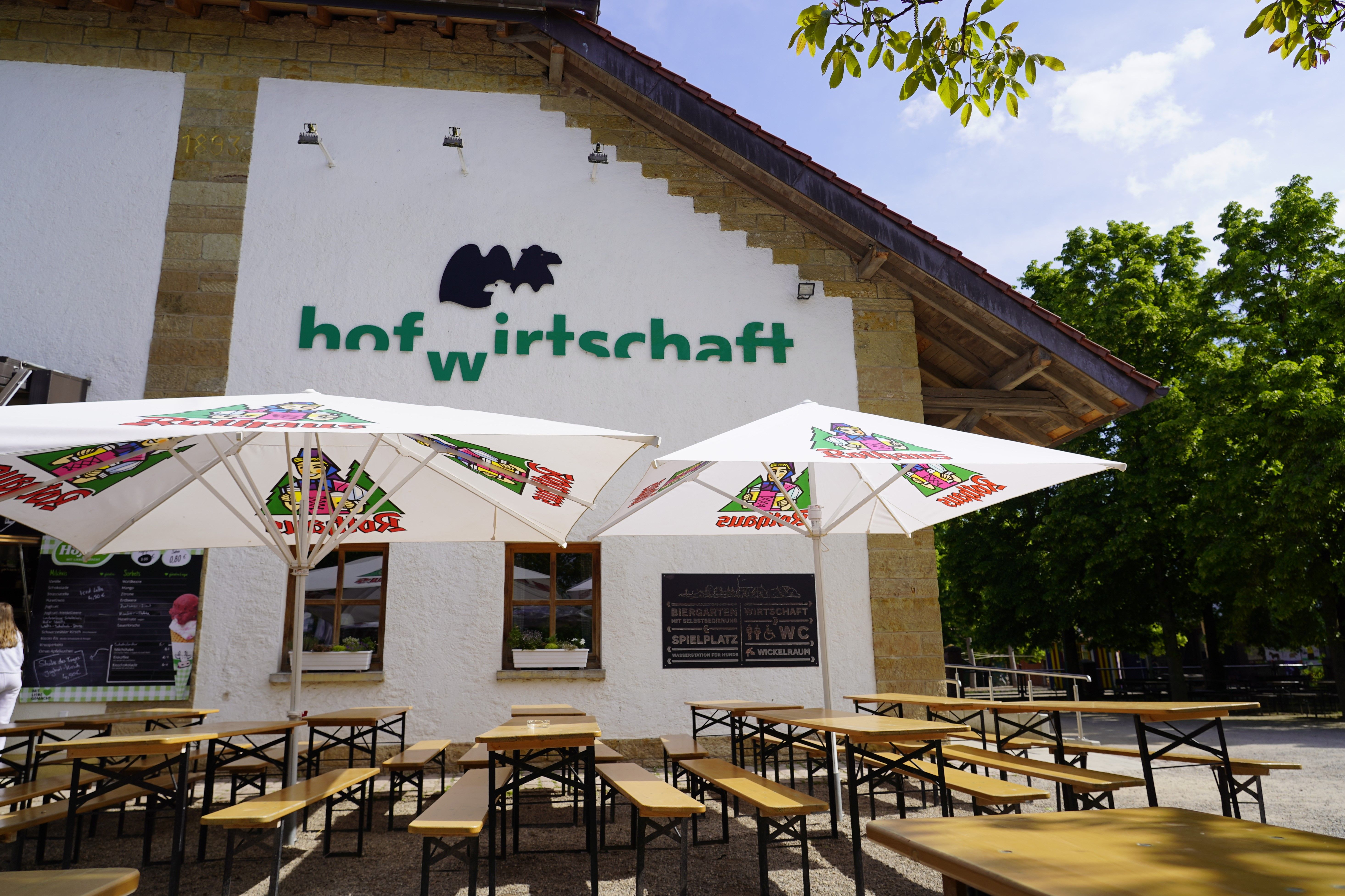 Hofwirtschaft im Mundenhof Freiburg mit Biergarten, Holzbänken und ländlicher Atmosphäre.