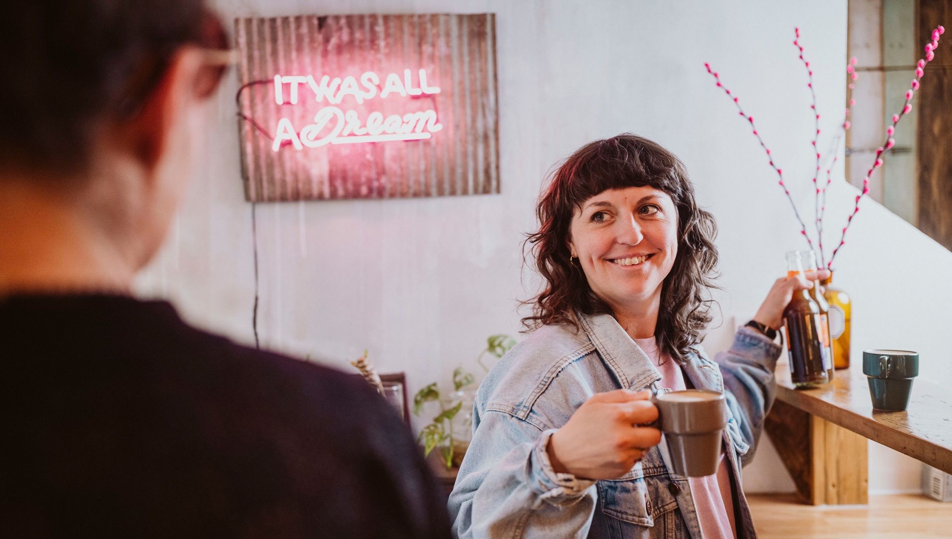 Frau bestellt im Café Hinterzimmer Getränke