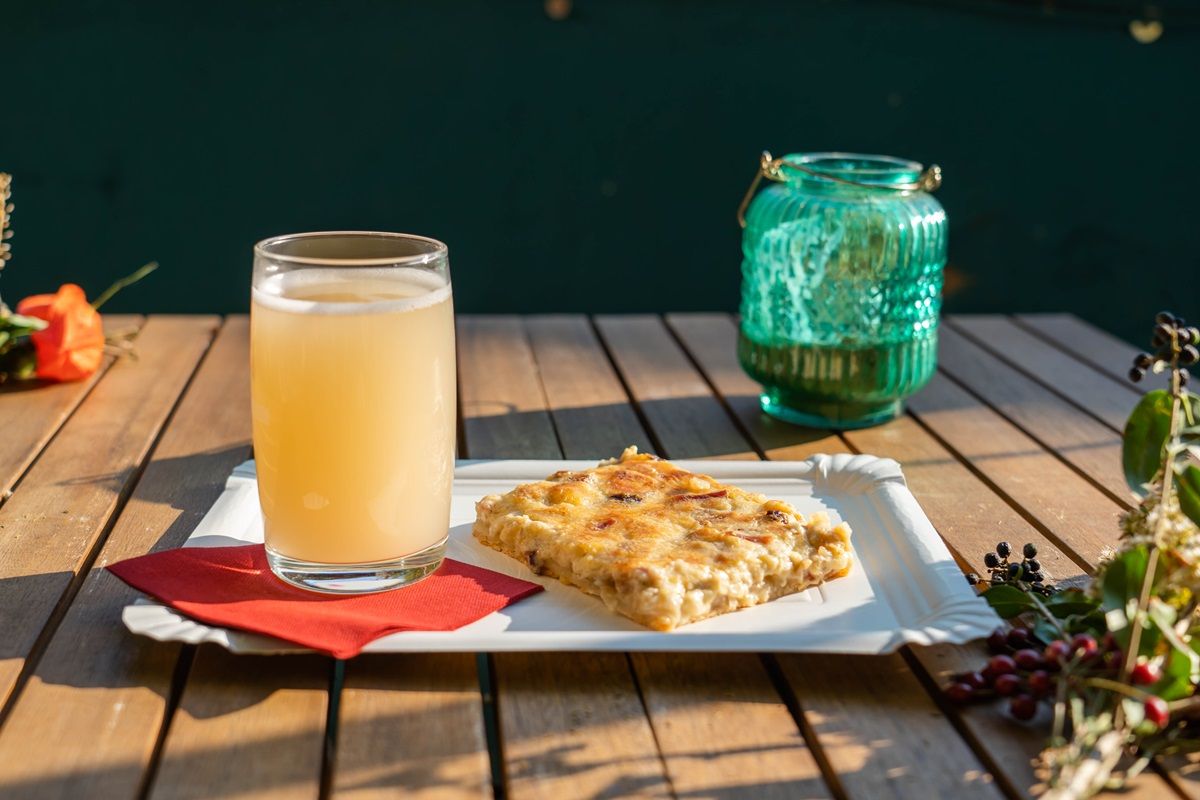 Zwiebelkuchen und neuer Süßer auf einem Tisch in einer Gartenwirtschaft