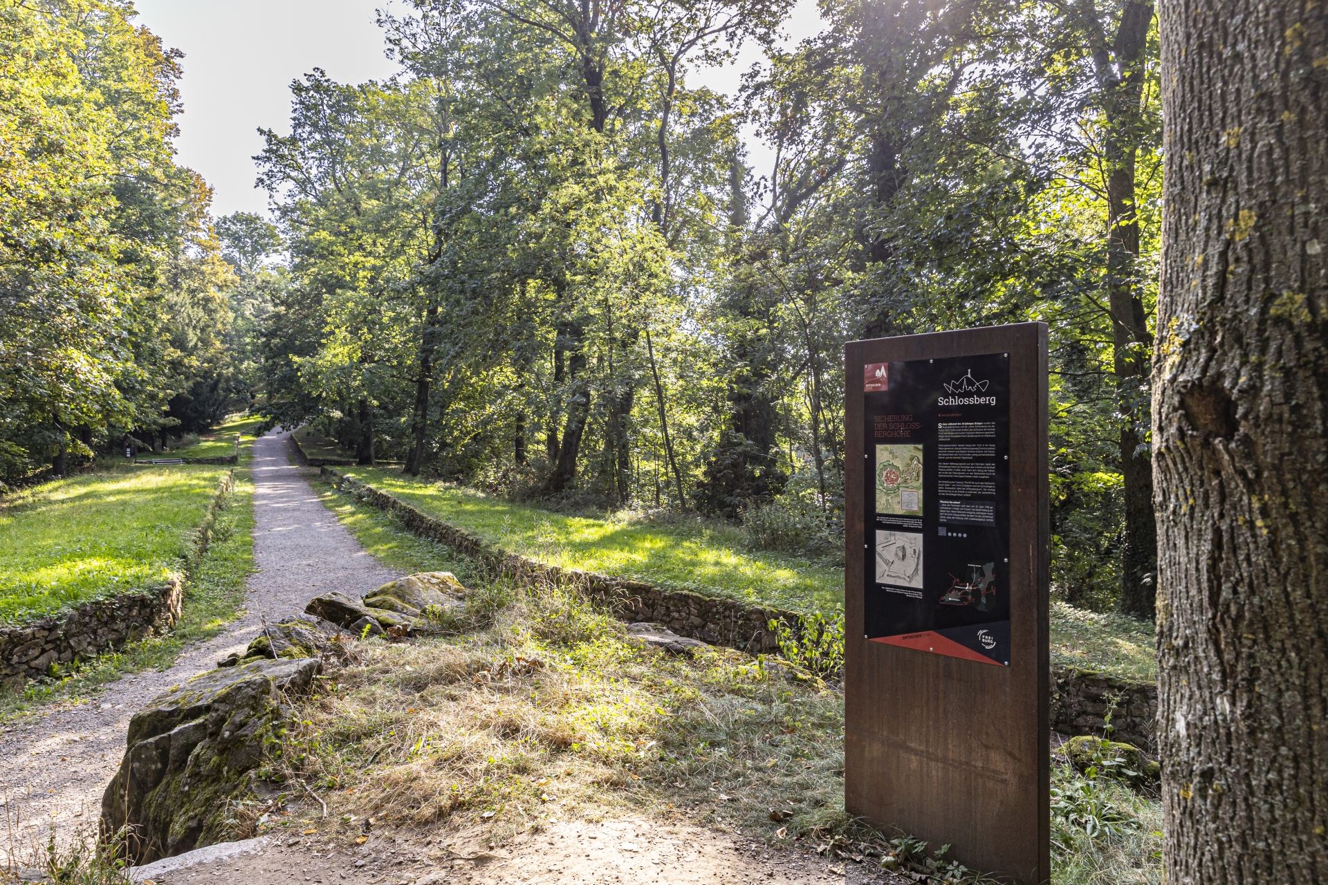 Die "Communication" am Schlossberg Freiburg mit einer Informationstafel im Vordergrund.