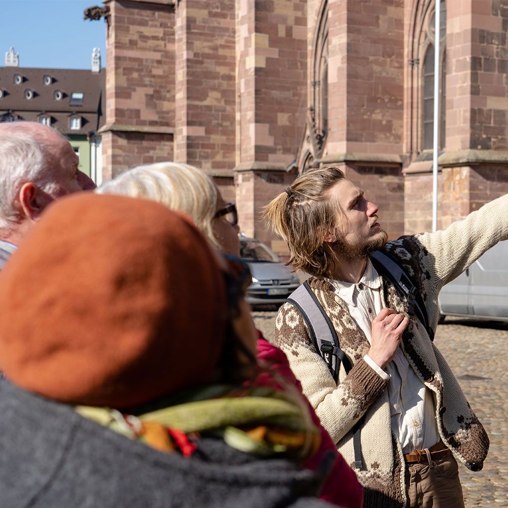 Gruppe von Menschen Nahaufnahme bei der Stadtführung in Freiburg auf dem Münsterpltz