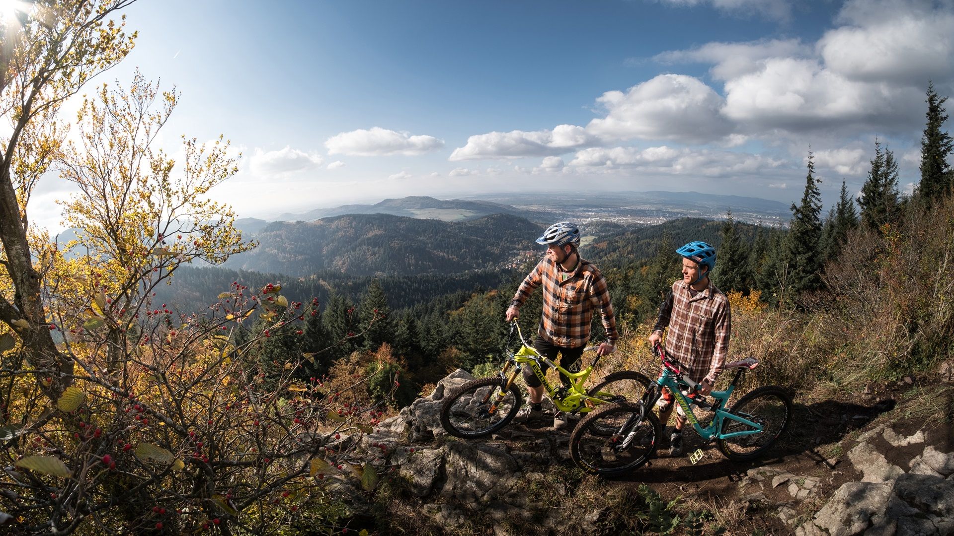 Zwei Mountainbiker an einem Abhang mit Blick auf den Schwarzwald 