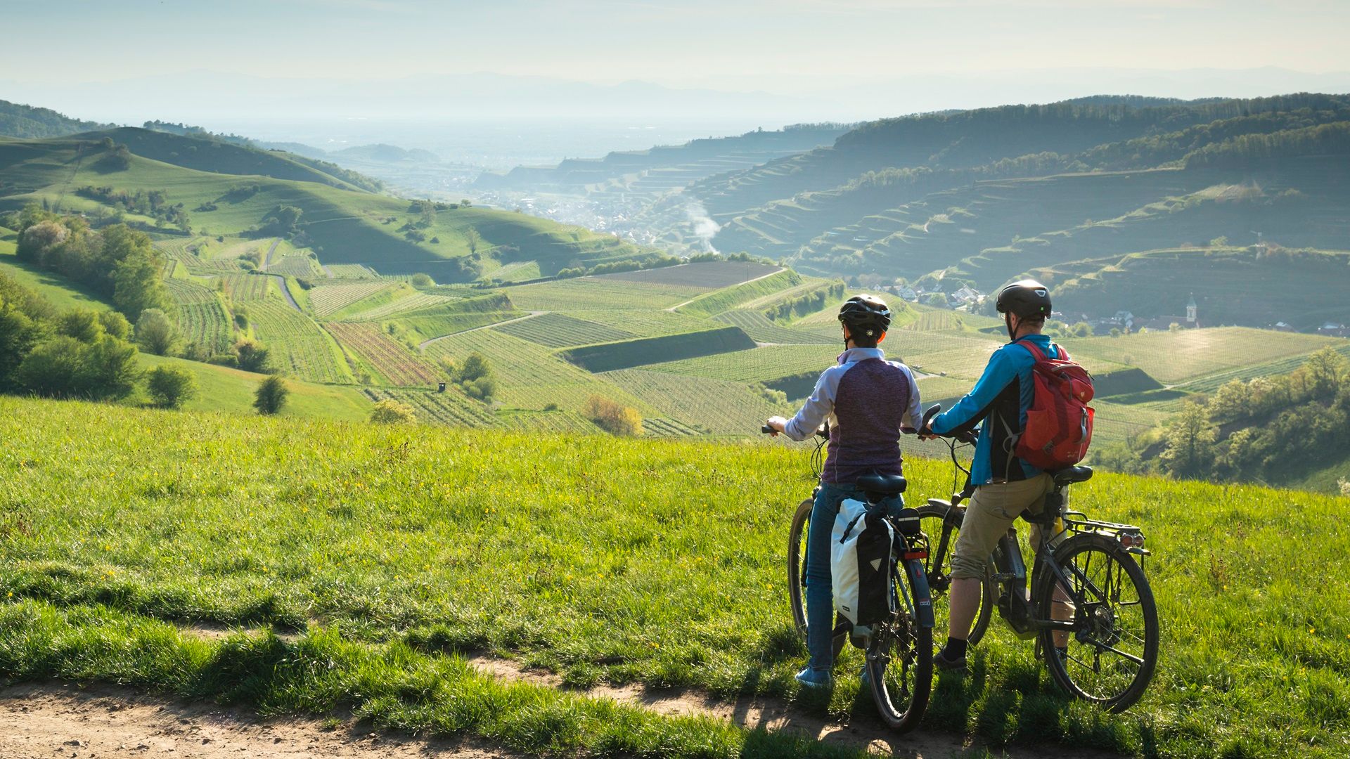 Zwei Fahrradfahrer in Vogtsburg im Kaiserstuhl mit Blick über die Landschaft