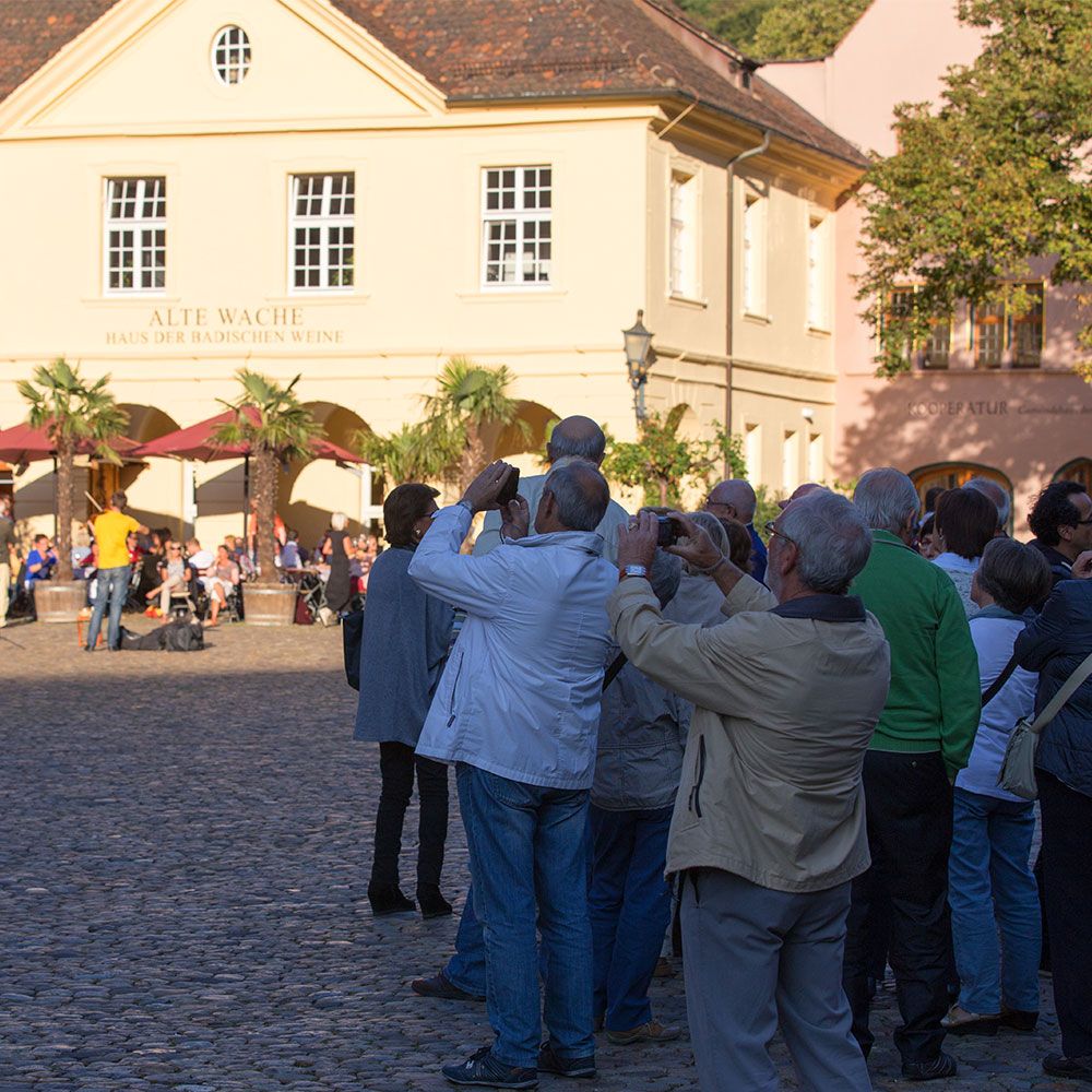 Freiburg Stadtführung Gruppe macht Fotos vom Münster vor dem Haus der alten Wache